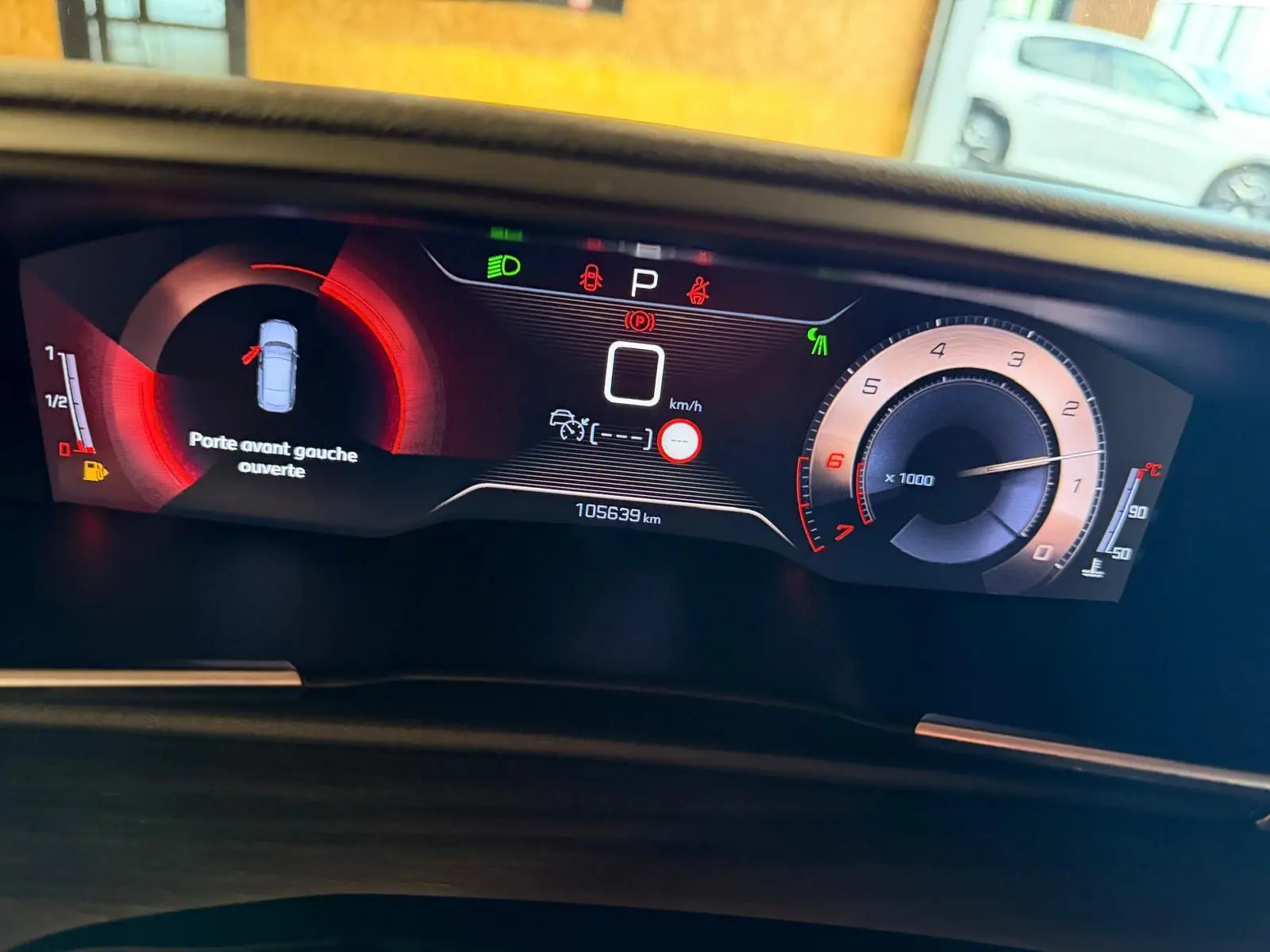 Vue rapprochée du tableau de bord numérique de la Peugeot 508 gris, affichant porte avant gauche ouverte et compte-tours.