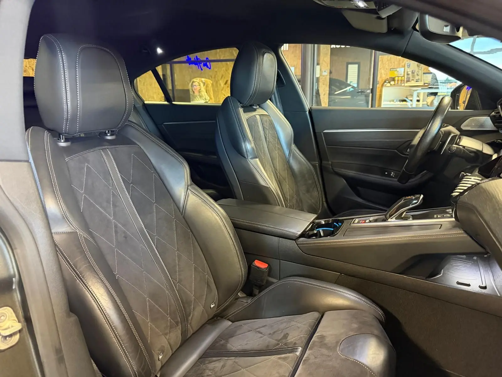 Vue intérieure côté gauche de la Peugeot 508 gris, mettant en valeur les sièges cuir noir et Alcantara avec surpiqûres blanches.