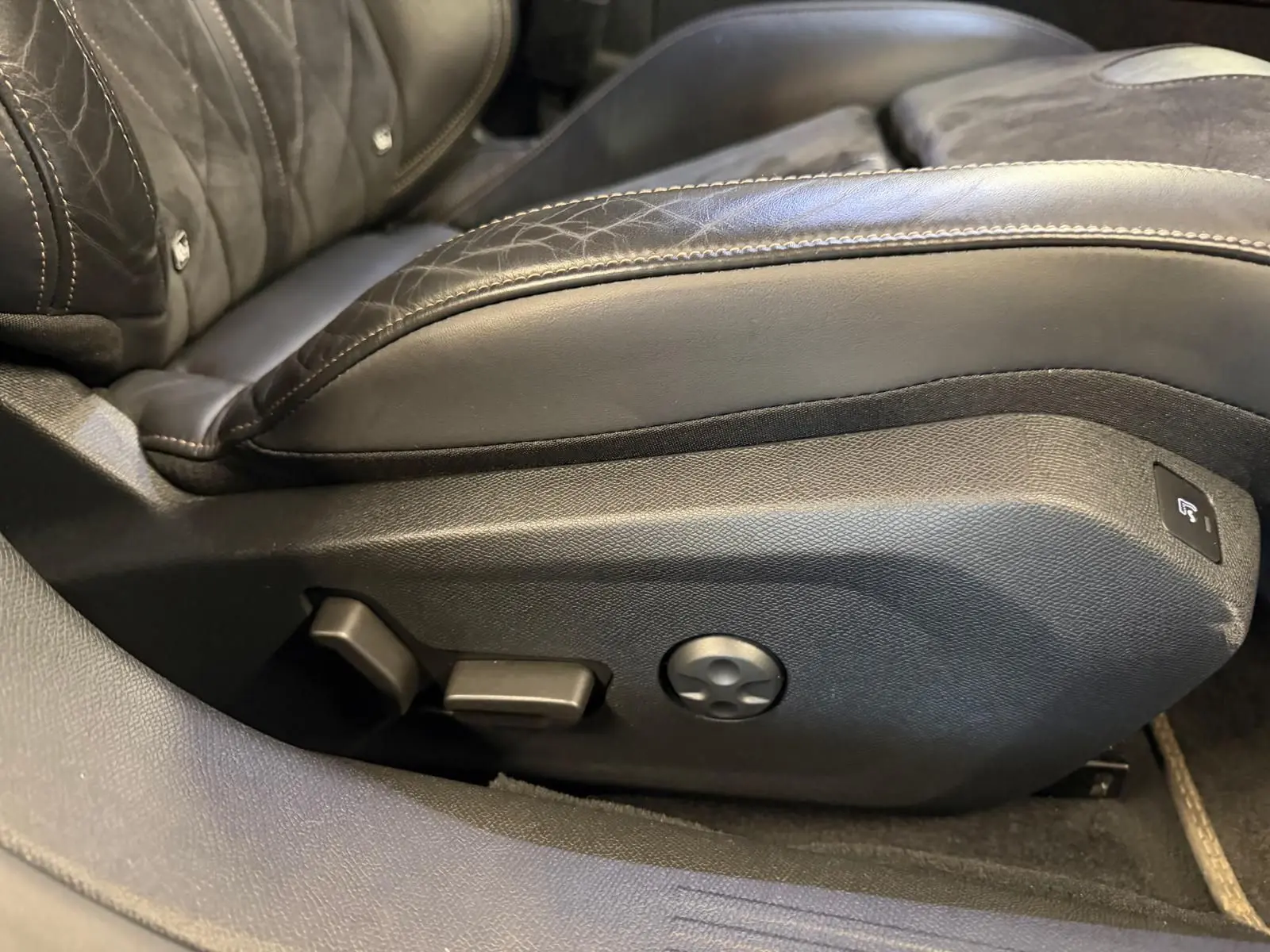 Détail du côté gauche du siège conducteur en cuir noir avec commandes électriques sur Peugeot 508 gris 2019.