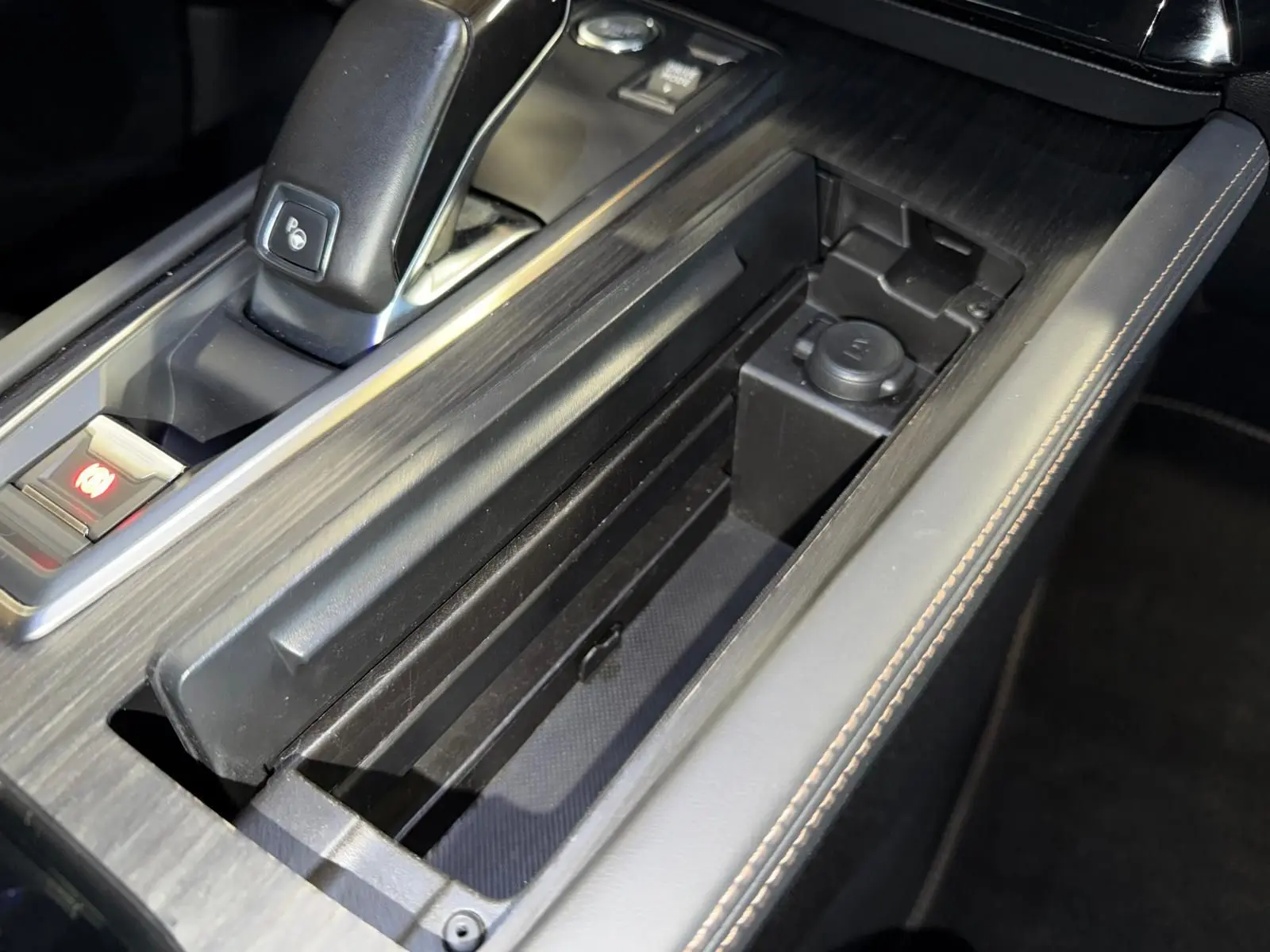 Vue rapprochée de la console centrale de la Peugeot 508 gris, avec levier de vitesse et rangement ouvert.