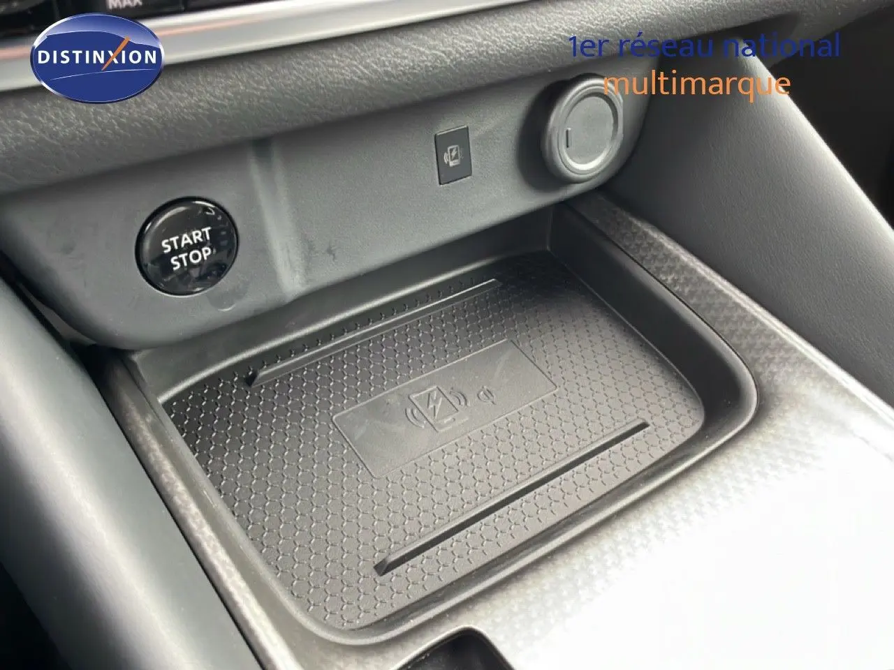 Gros plan sur la console centrale du Nissan Qashqai 2025 montrant le plateau de charge sans fil et le bouton start/stop.