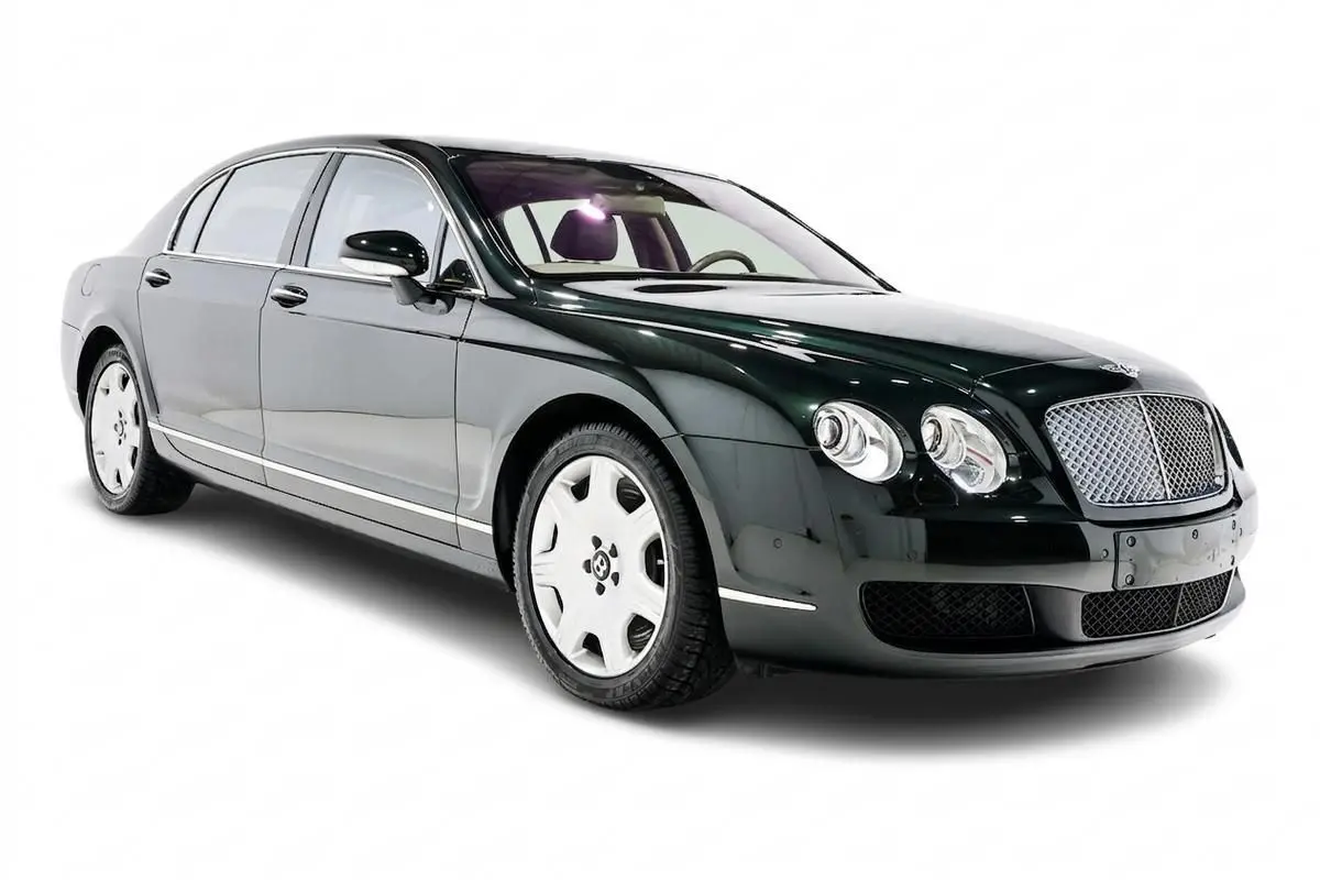 Bentley Continental Flying Spur vert foncé vue 3/4 avant droit avec calandre chromée et jantes blanches.