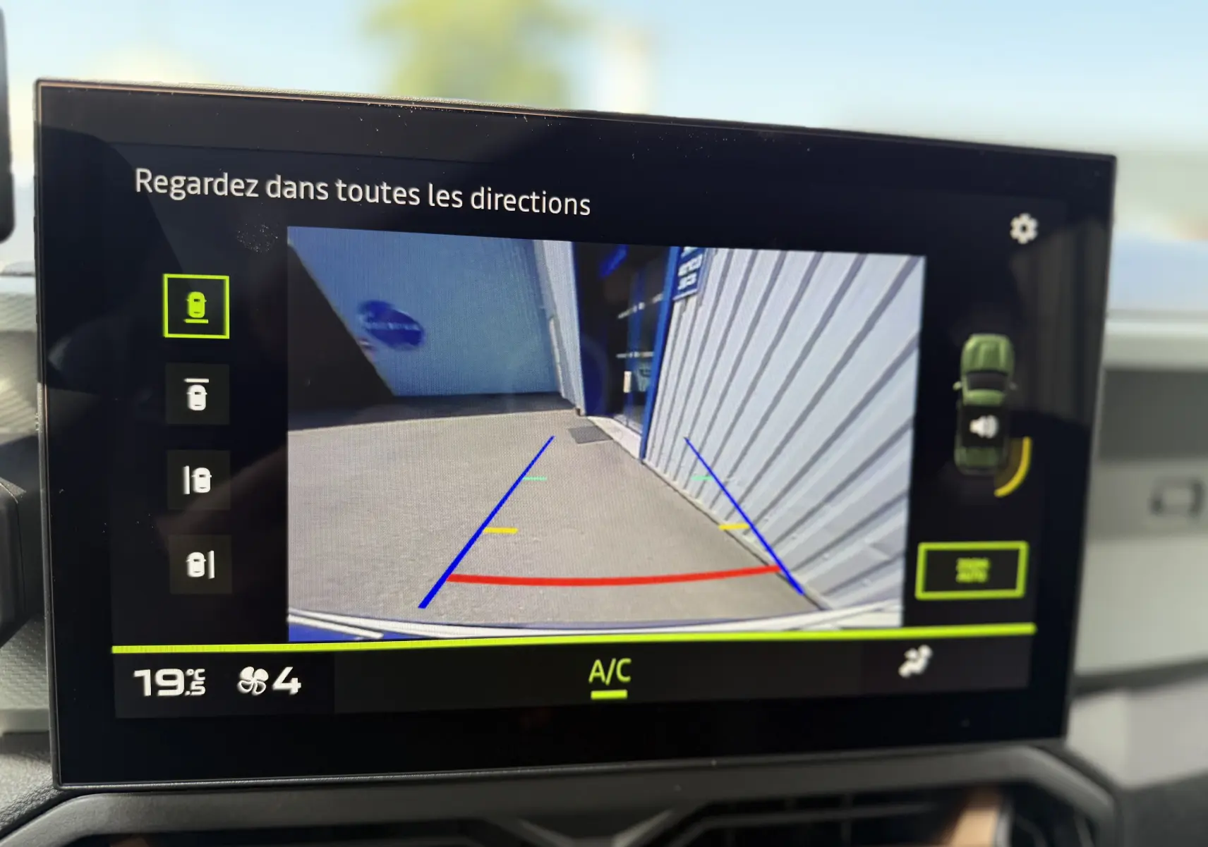 Écran intérieur du Dacia Duster Hybrid 155 Extreme montrant la caméra de recul avec lignes de guidage colorées.