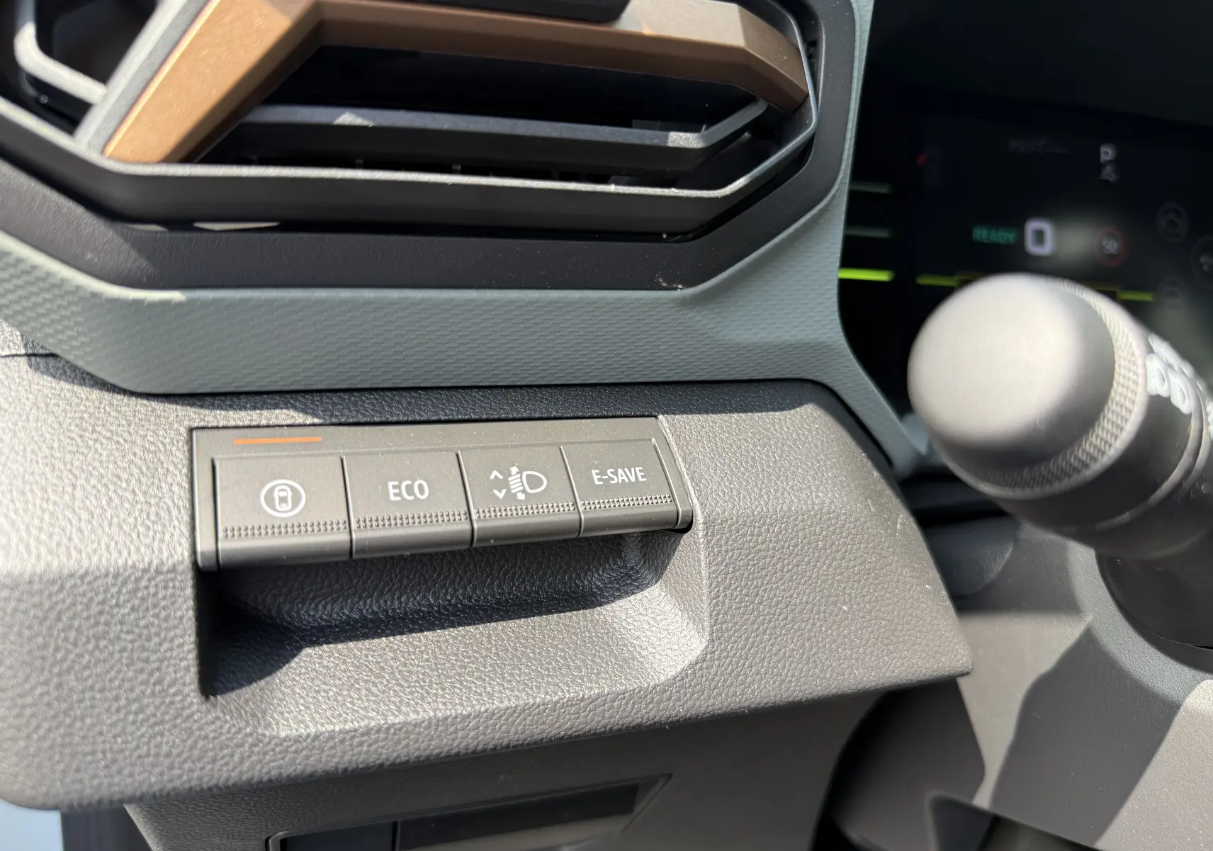 Gros plan sur les boutons de commande à gauche du volant dans le tableau de bord du Dacia Duster Hybrid 155 Extreme.