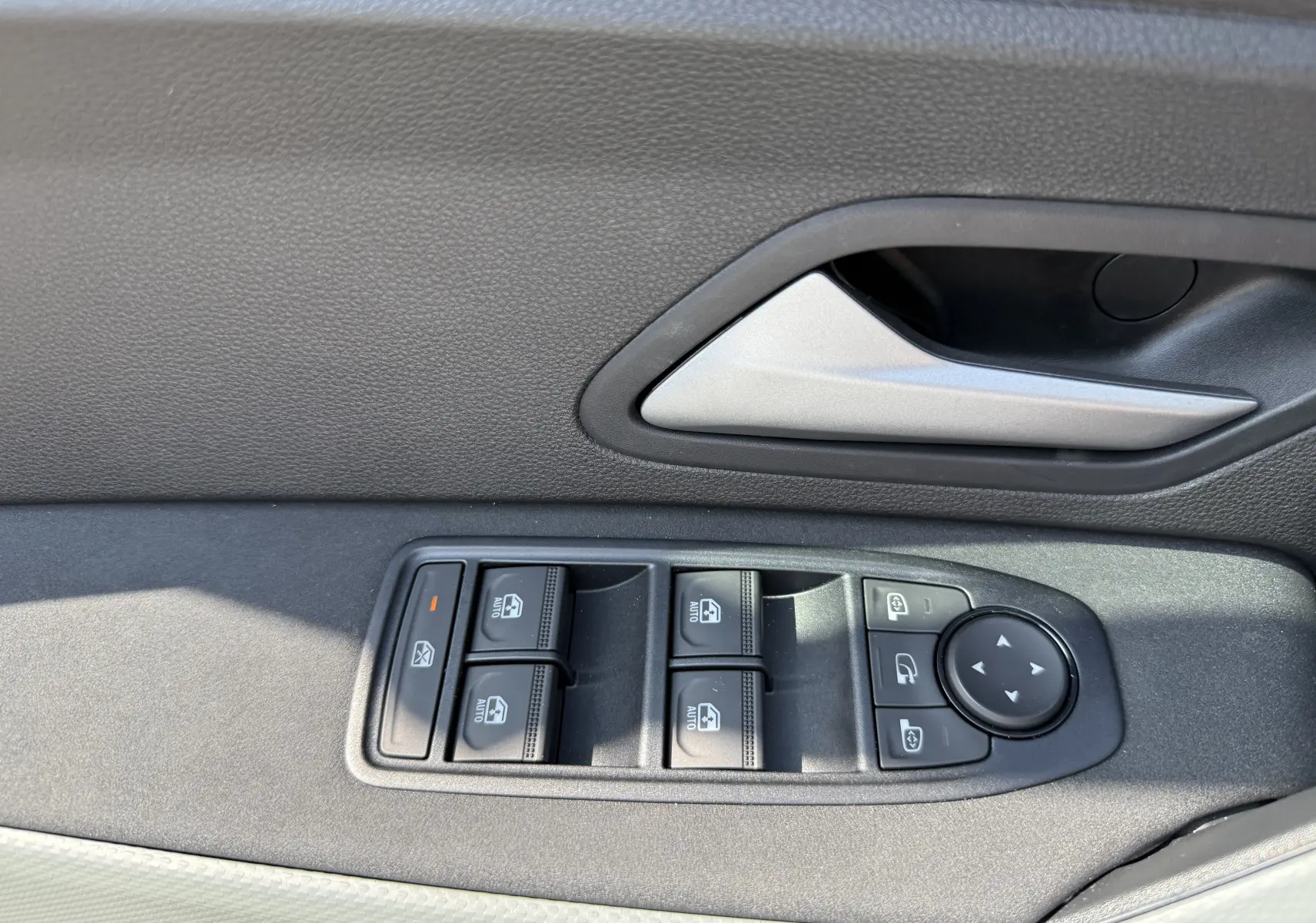Détail des commandes de lève-vitres et rétroviseurs sur la porte côté conducteur du Dacia Duster Hybrid 155 Extreme blanc glacier.