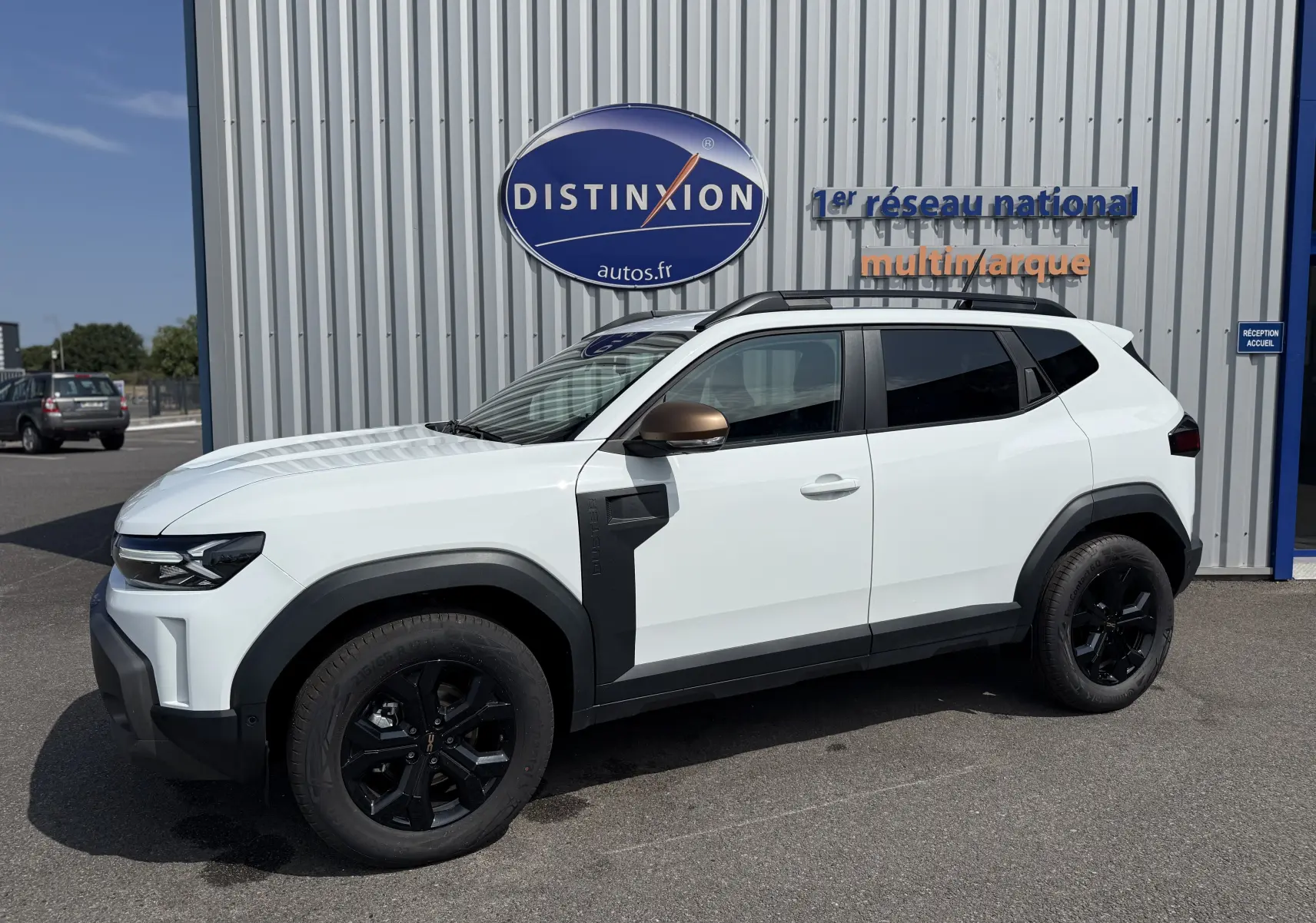 Vue de profil côté gauche d'un Dacia Duster Hybrid 155 Extreme blanc glacier avec jantes noires et rétroviseurs bronze.