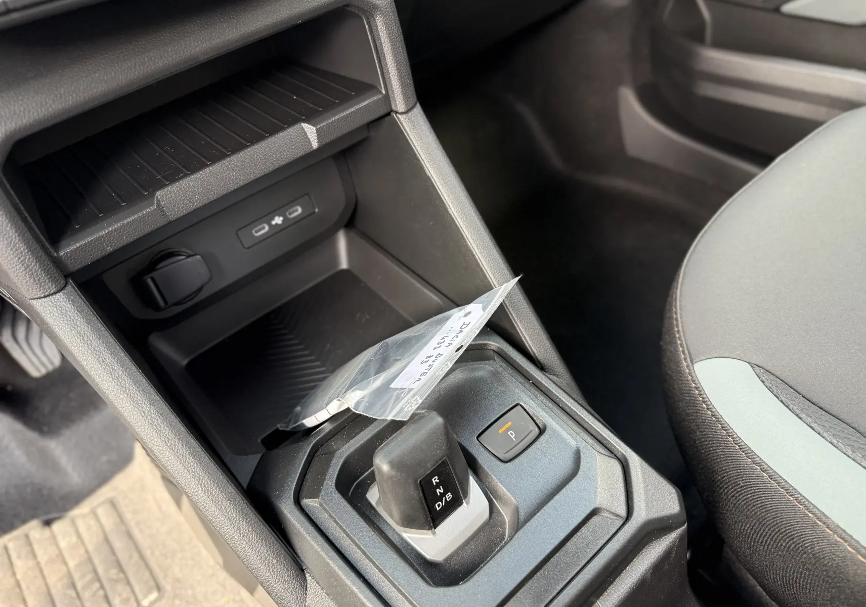Gros plan sur la console centrale du Dacia Duster Hybrid 155 Extreme 2026, montrant le levier de boîte automatique et les ports USB.