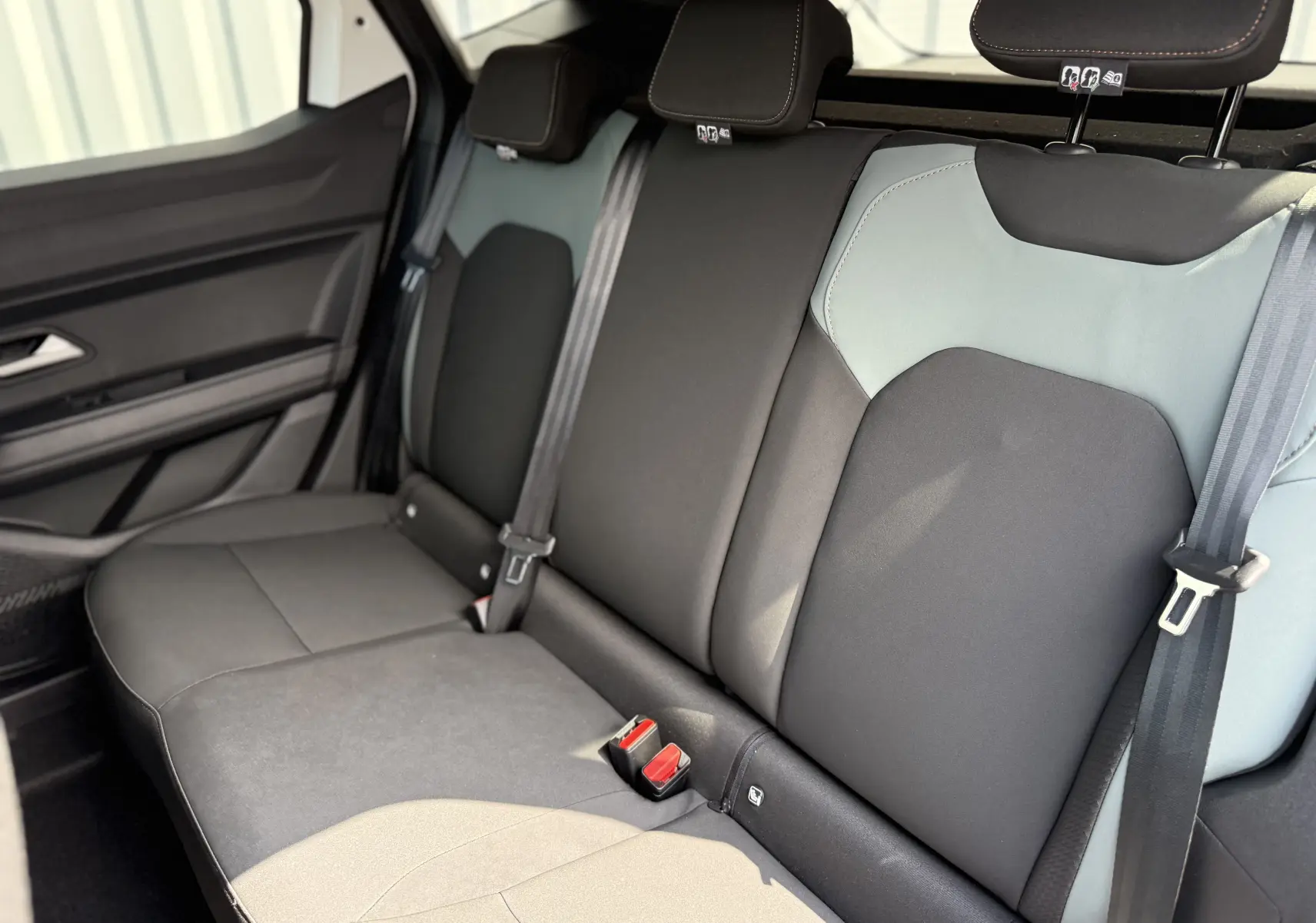 Vue intérieure de la banquette arrière du Dacia Duster Hybrid 155 Extreme avec sièges tissu bicolores gris et noir.
