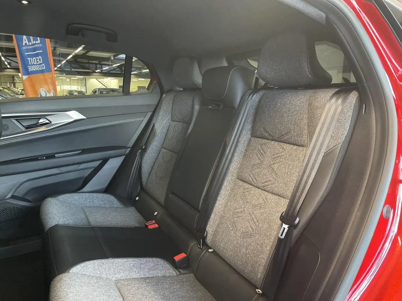 Vue intérieure côté droit sur la banquette arrière bi-matière gris clair et noir du Renault Rafale rouge 2025.