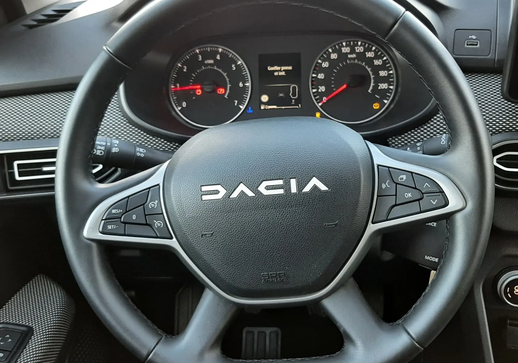 Vue rapprochée du volant noir de la Dacia Jogger 2025 avec tableau de bord et commandes au volant visibles.