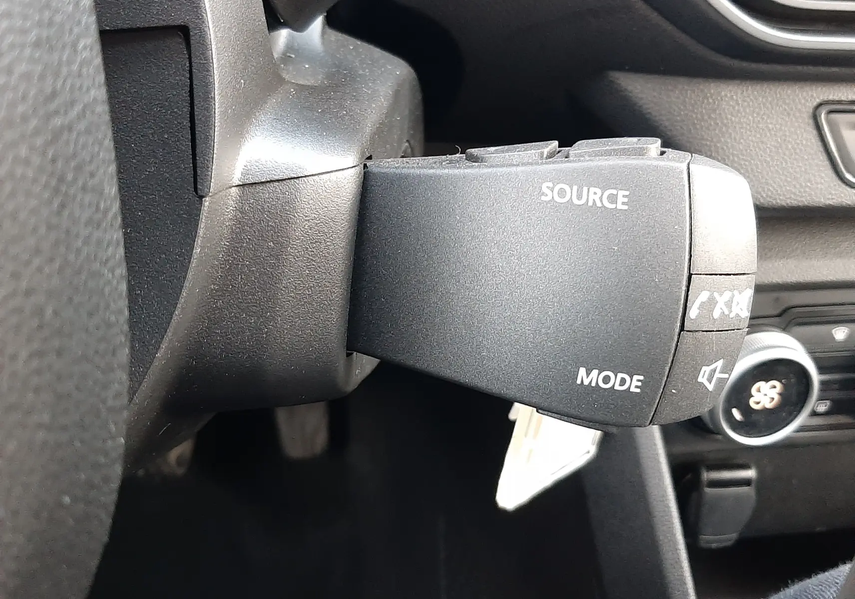 Gros plan sur la commande multimédia au volant du Dacia Jogger 2025, intérieur noir avec détails de la console.