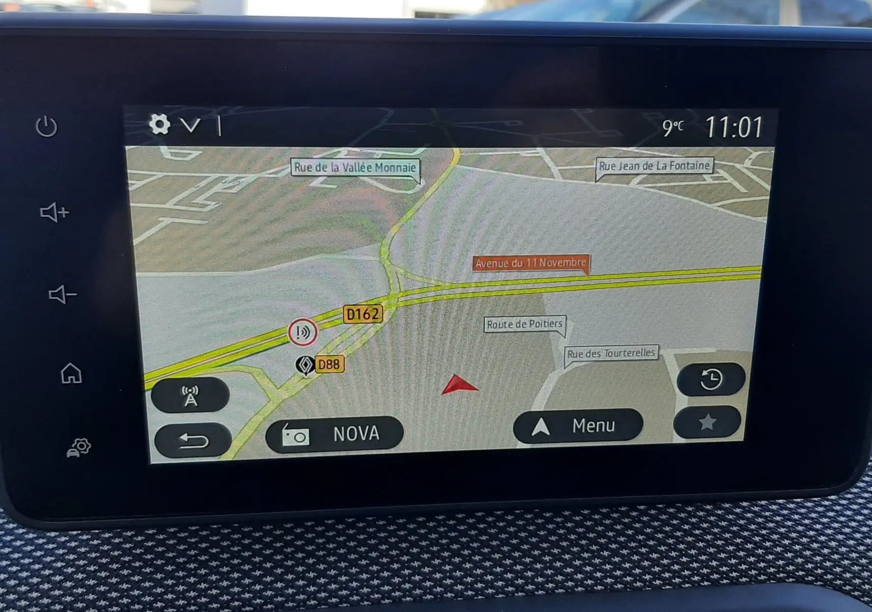 Écran tactile central affichant la navigation GPS dans un Dacia Jogger, intérieur avec tableau de bord texturé gris.