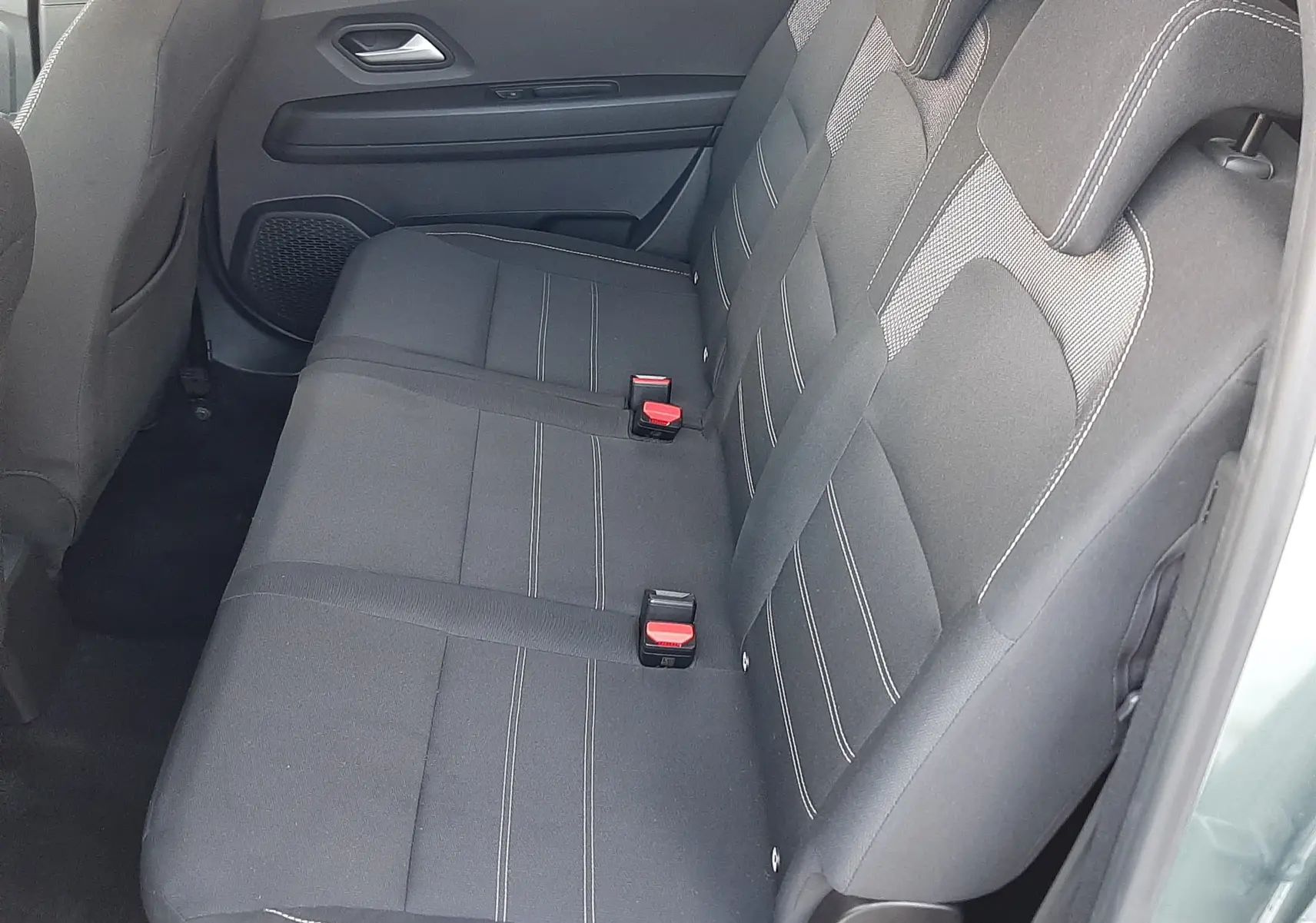 Vue intérieure côté droit des sièges arrière noirs en tissu du Dacia Jogger vert cèdre métal 2025.