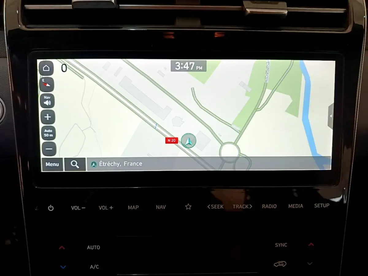 Écran tactile central affichant la navigation 3D dans un Hyundai Tucson gris foncé, vue intérieure rapprochée.
