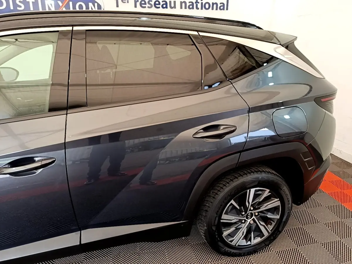 Vue latérale droite du Hyundai Tucson 1.6 Hybrid 230 Creative gris foncé, mettant en valeur les lignes et la roue arrière.