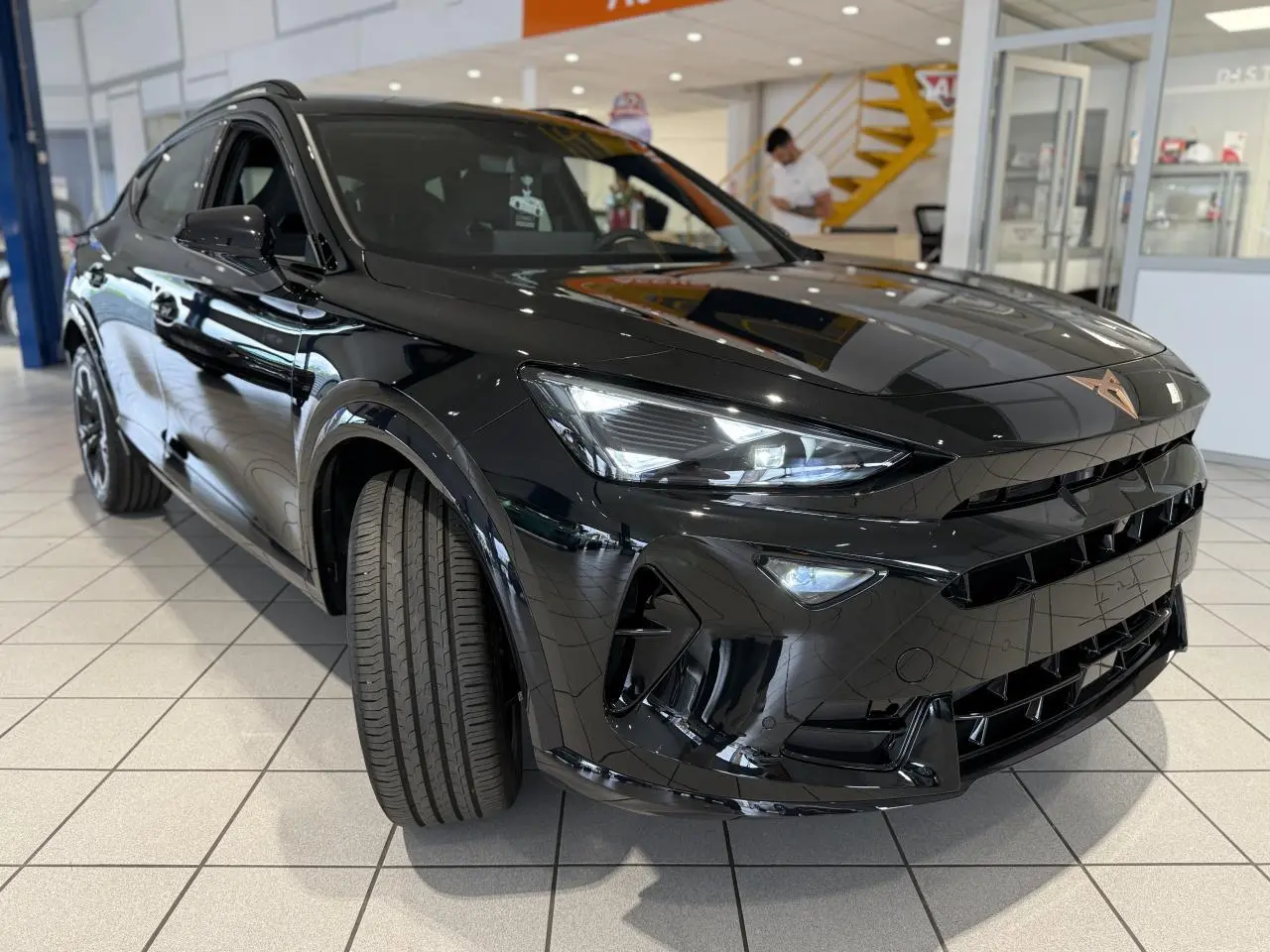 Vue 3/4 avant droit d'un CUPRA Formentor noir Night avec phares LED allumés et jantes alliage 18 pouces.