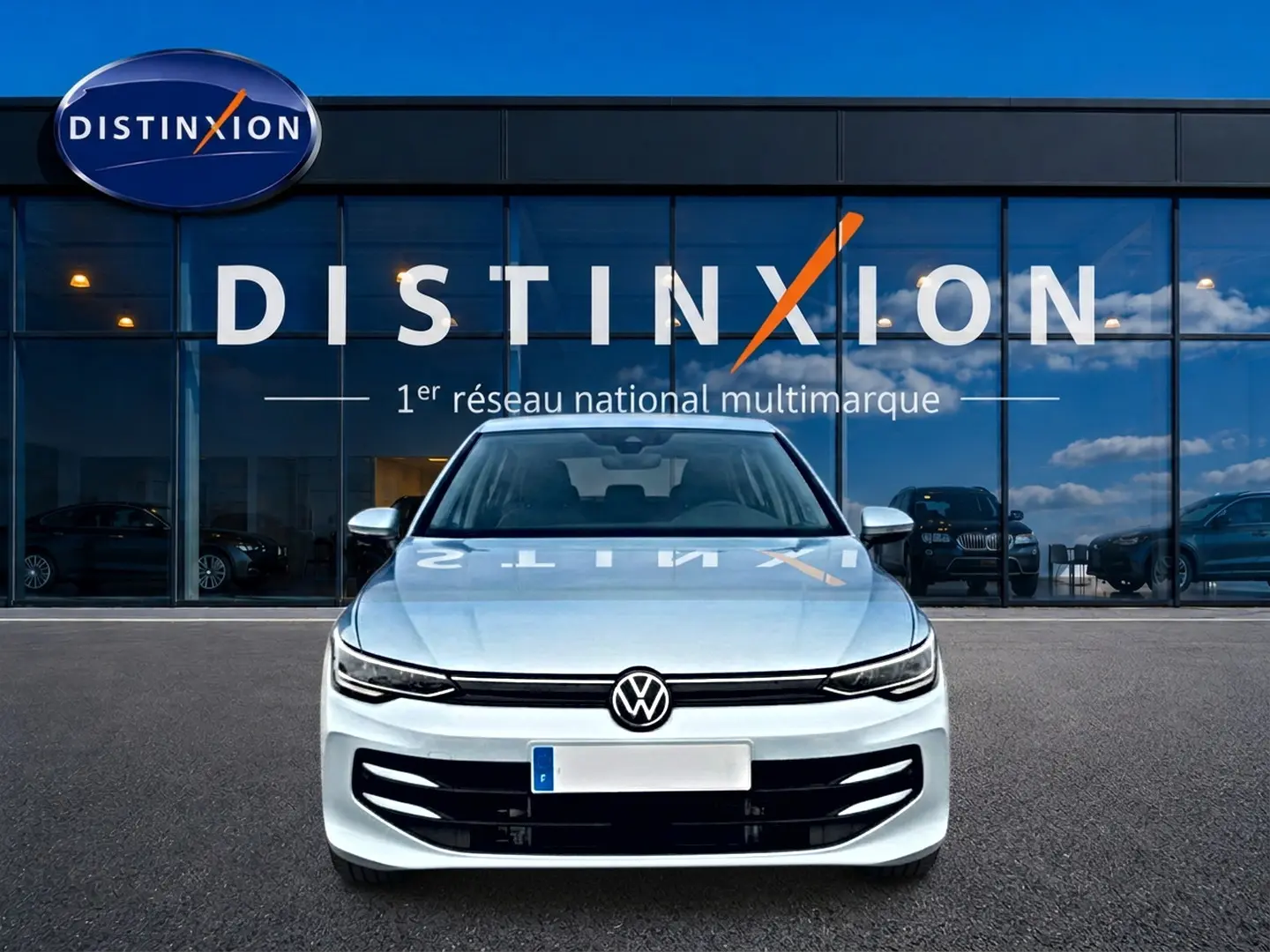 Volkswagen Golf 1.5 ETSI Evo2 bleu glacier vue de face devant une vitrine avec logo Distinxion.