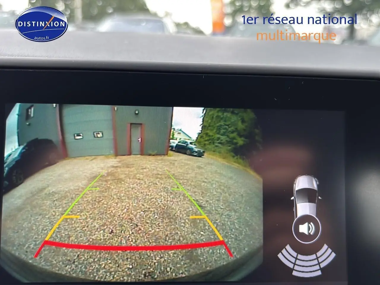 Vue caméra arrière de la Renault Clio V noire Étoilé montrant l’aire de stationnement avec guidage de recul coloré.