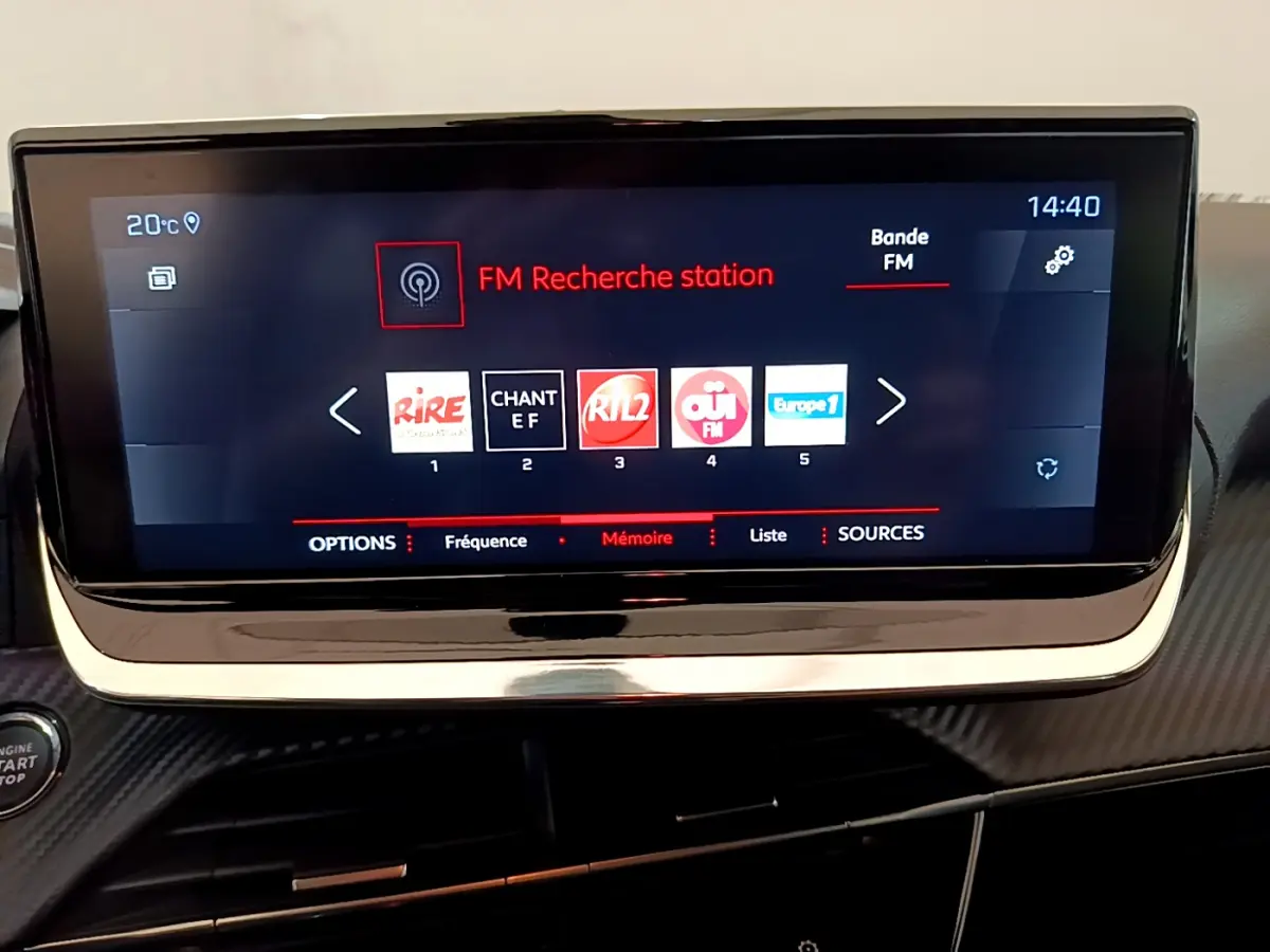 Écran tactile central de 7 pouces affichant la radio FM dans l'habitacle d'une Peugeot 208 blanche de 2020.
