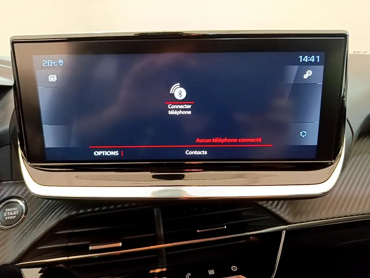 Écran tactile central de 7 pouces affichant la connexion Bluetooth dans l'habitacle noir de la Peugeot 208 blanche.