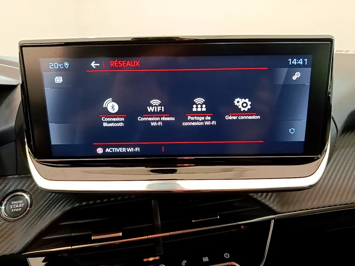 Écran tactile central affichant les options de connexion Wi-Fi et Bluetooth dans le tableau de bord noir du Peugeot 208 blanc.