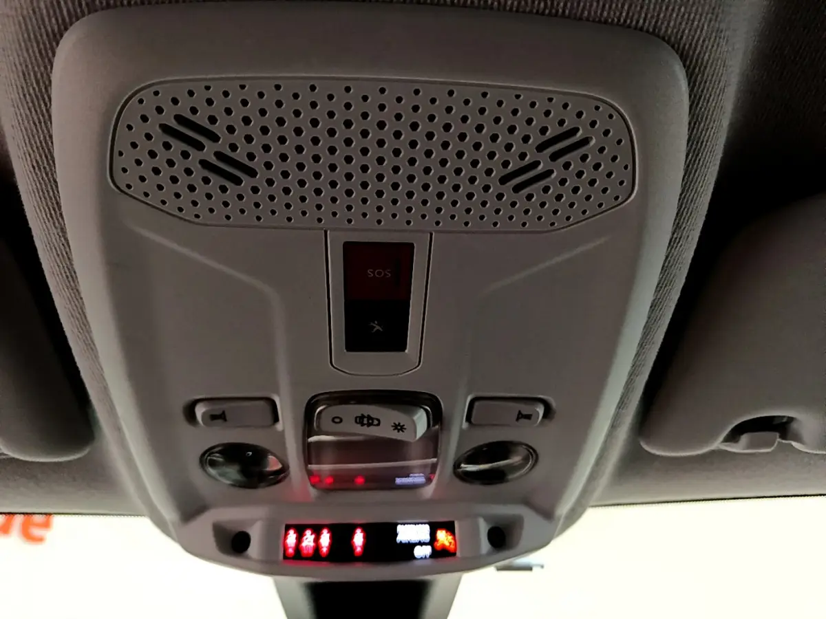 Vue en contre-plongée du plafonnier gris clair avec commandes d’éclairage et bouton SOS du Peugeot 208 blanc PureTech 2020