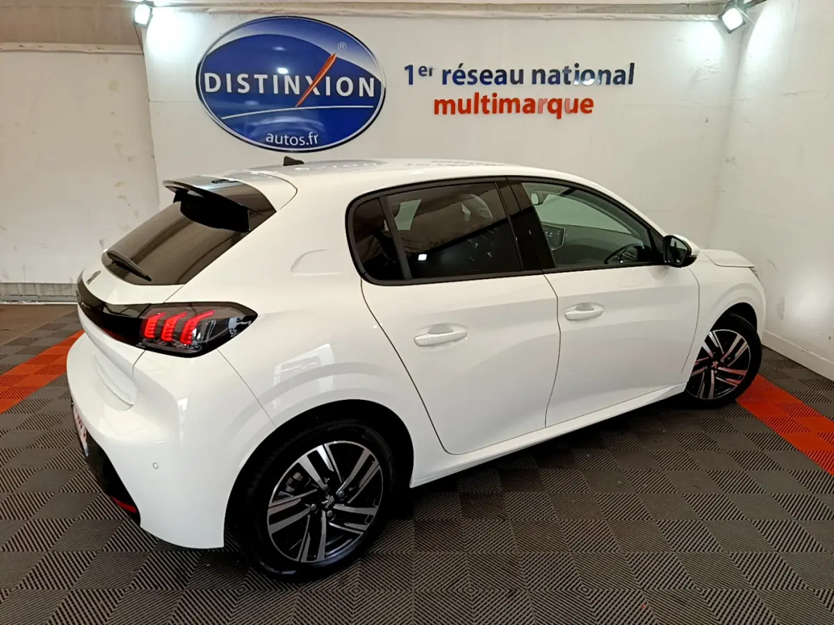 Peugeot 208 blanc vue 3/4 arrière côté droit, avec feux arrière LED et jantes alliage distinctives.