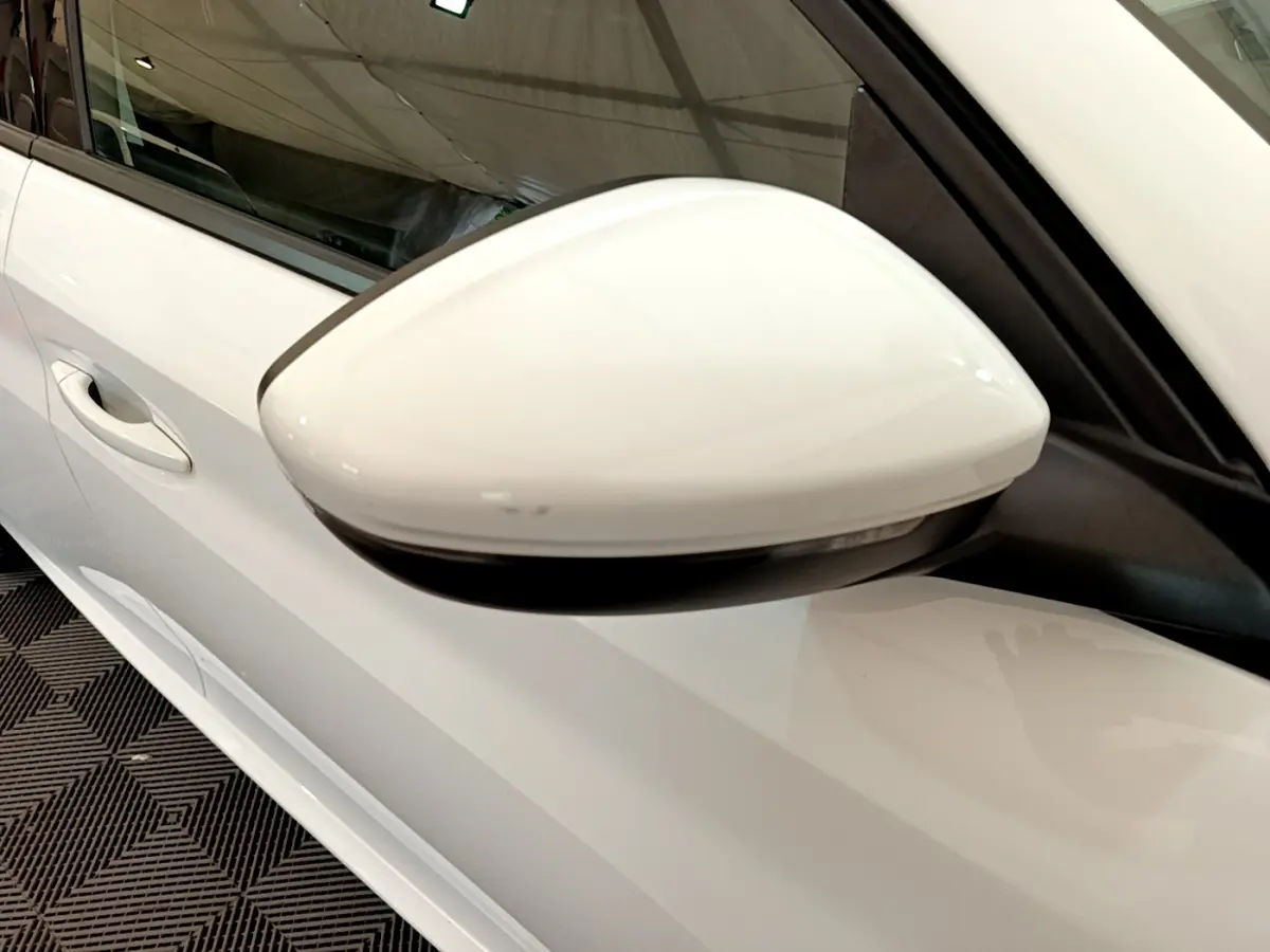 Rétroviseur blanc côté gauche d'une Peugeot 208 PureTech 100 S&S Allure Business 2020 vue en gros plan.
