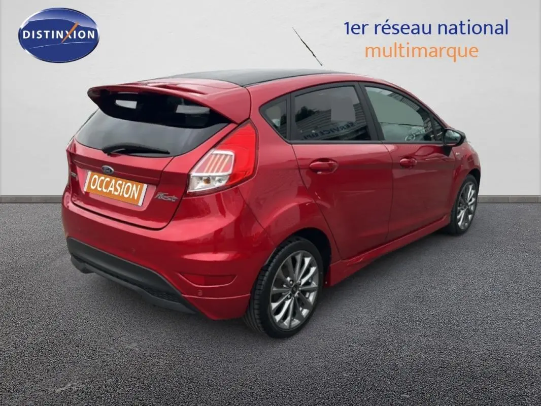 Vue 3/4 arrière droite d'une Ford Fiesta rouge 2017 avec jantes alliage et vitres surteintées.