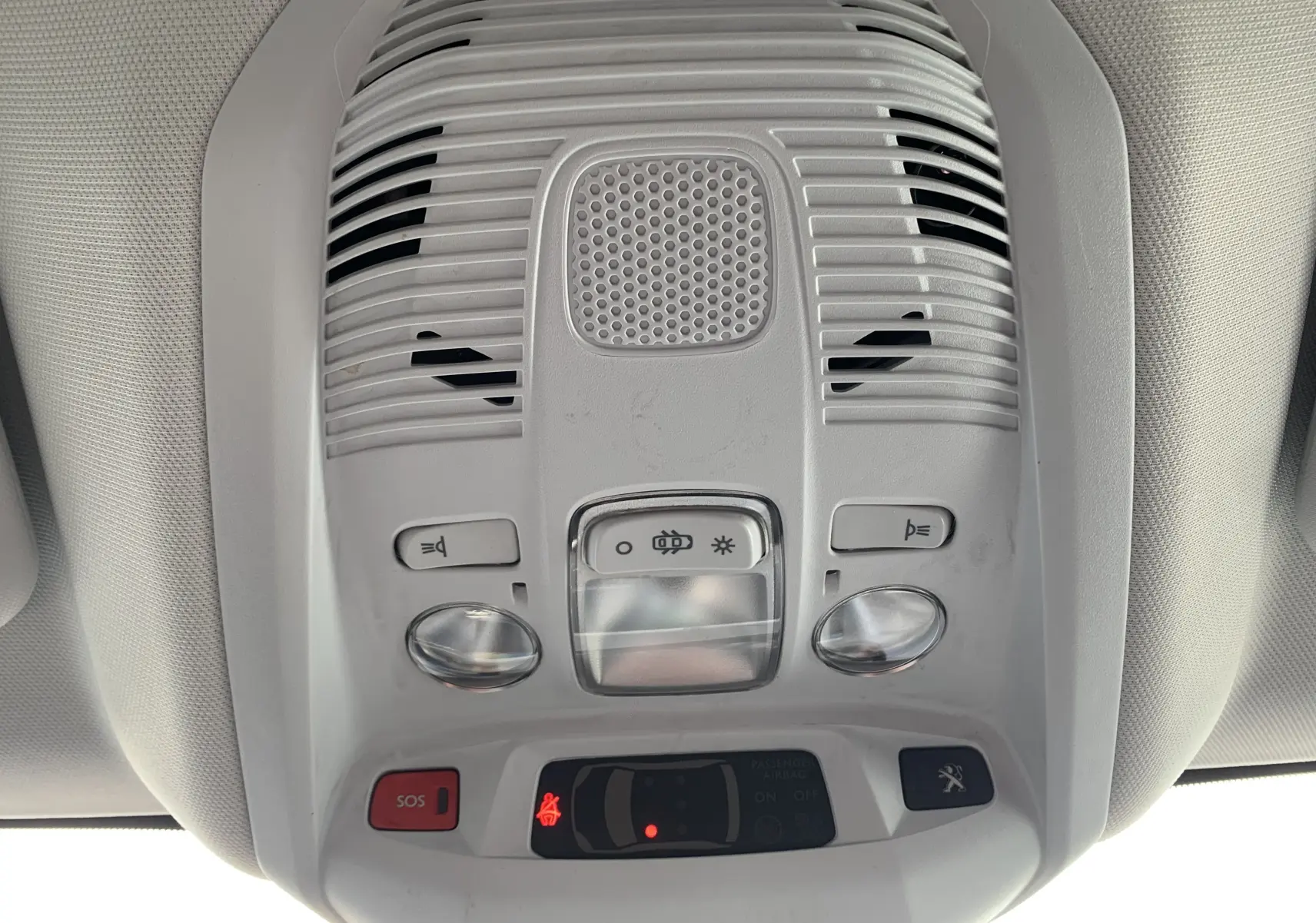 Vue en gros plan du plafonnier intérieur gris clair du Peugeot 3008 avec boutons d’éclairage et alerte SOS.