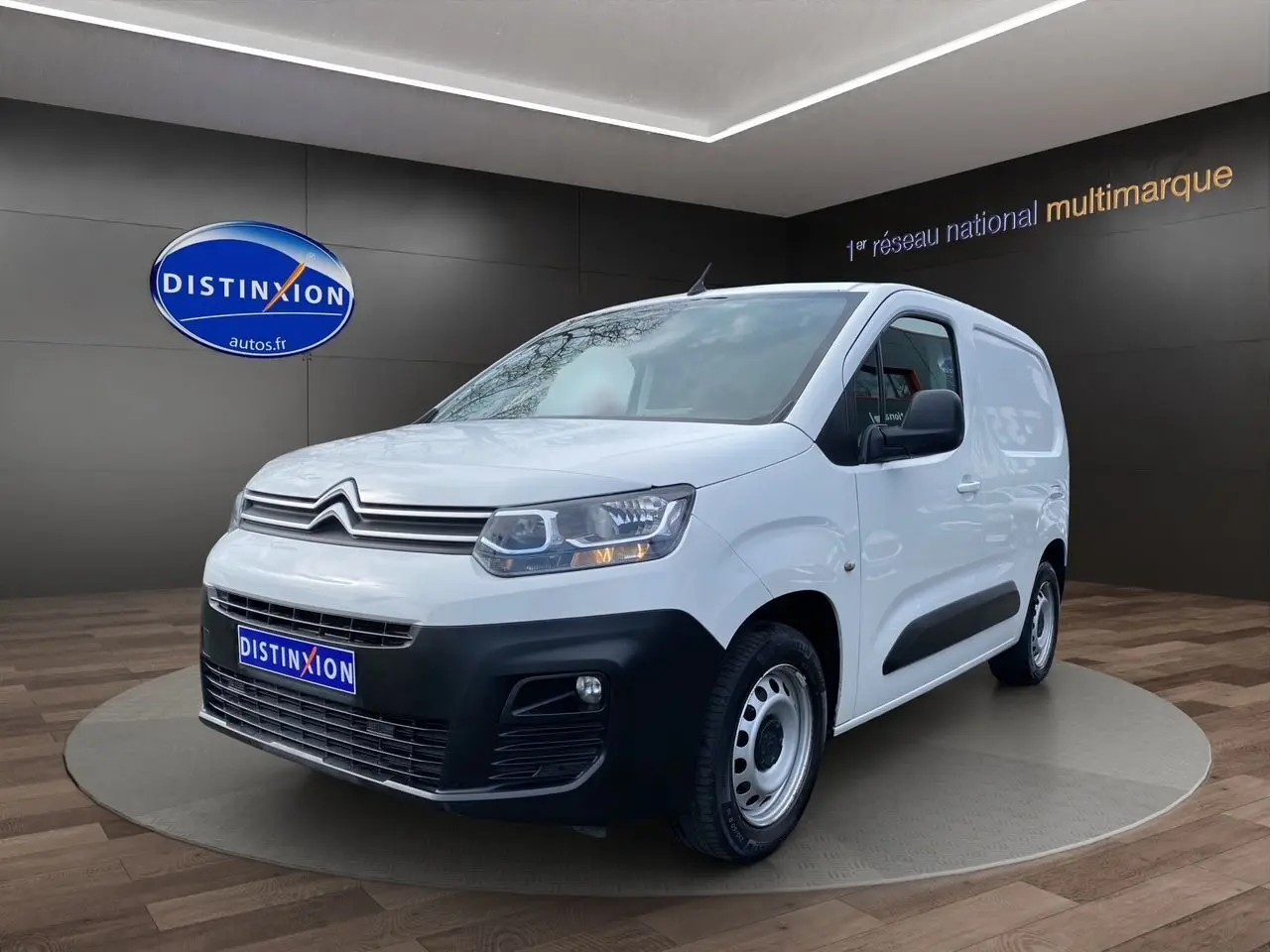 Citroën Berlingo blanc vu en 3/4 avant droit, utilitaire compact avec pare-chocs noirs et jantes acier simples.
