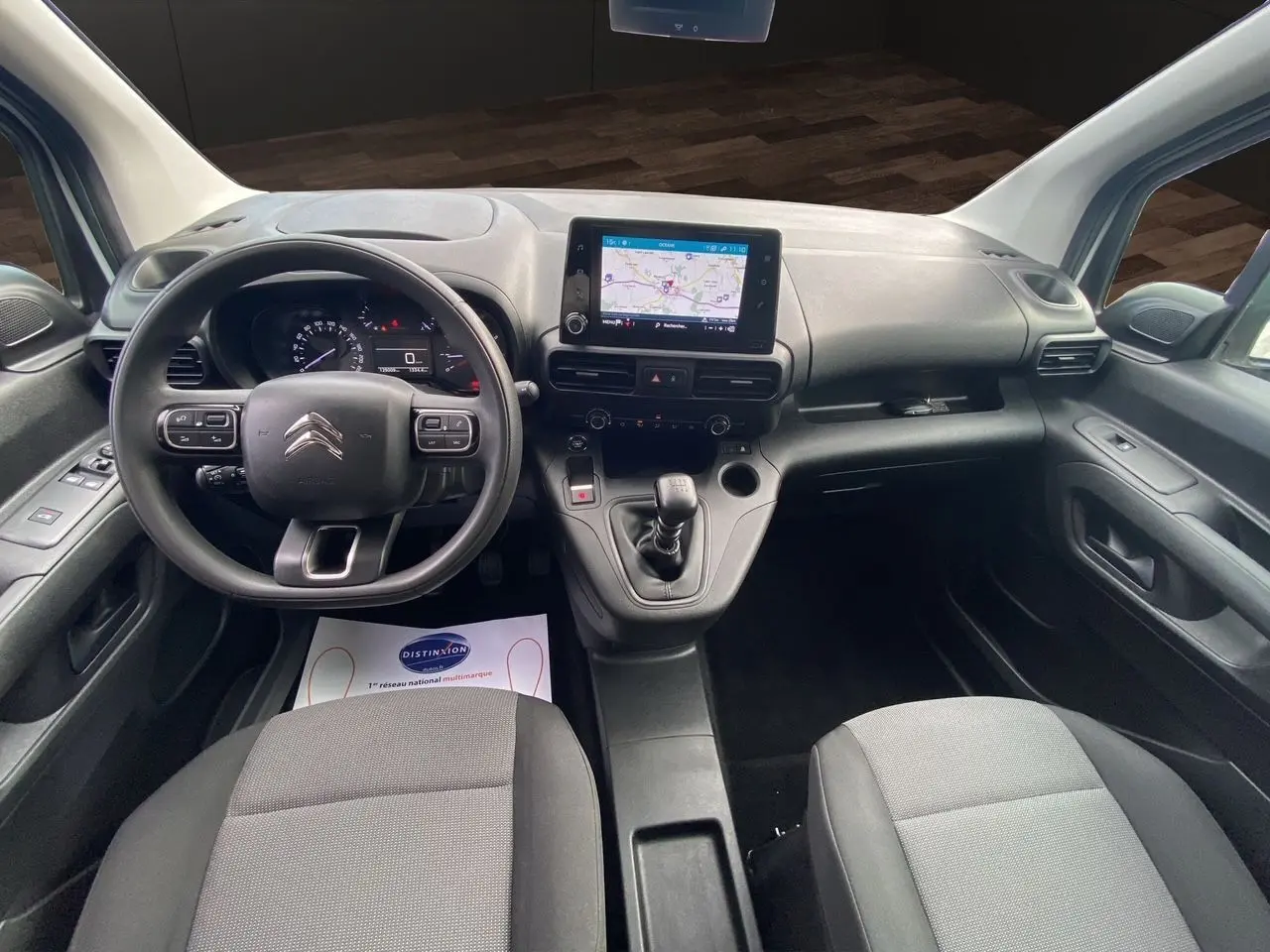 Vue intérieure du poste de conduite du Citroën Berlingo blanc 2019, avec tableau de bord et écran tactile central.