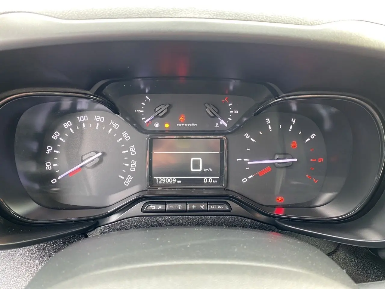 Vue rapprochée du tableau de bord du Citroën Berlingo blanc 2019, affichant le compteur et l'odomètre à 129009 km.