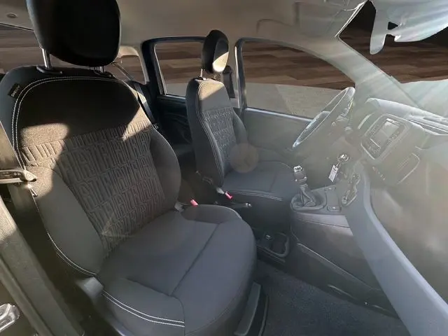 Intérieur noir de la Fiat Panda 2025 vu côté gauche, avec sièges tissu et tableau de bord équipé d’un écran multimédia.