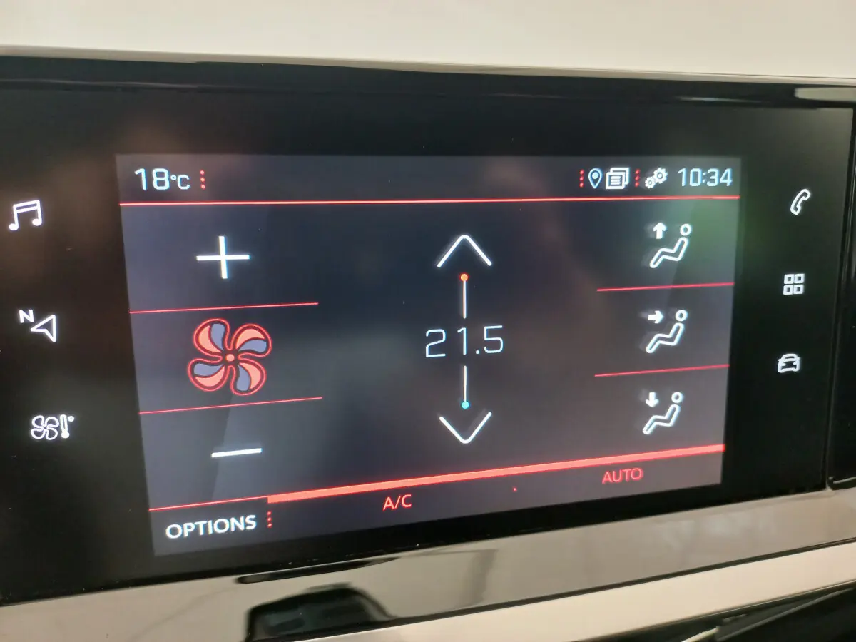 Écran tactile du système de climatisation affichant 21,5°C dans une Peugeot 208 blanche, vue intérieure rapprochée.