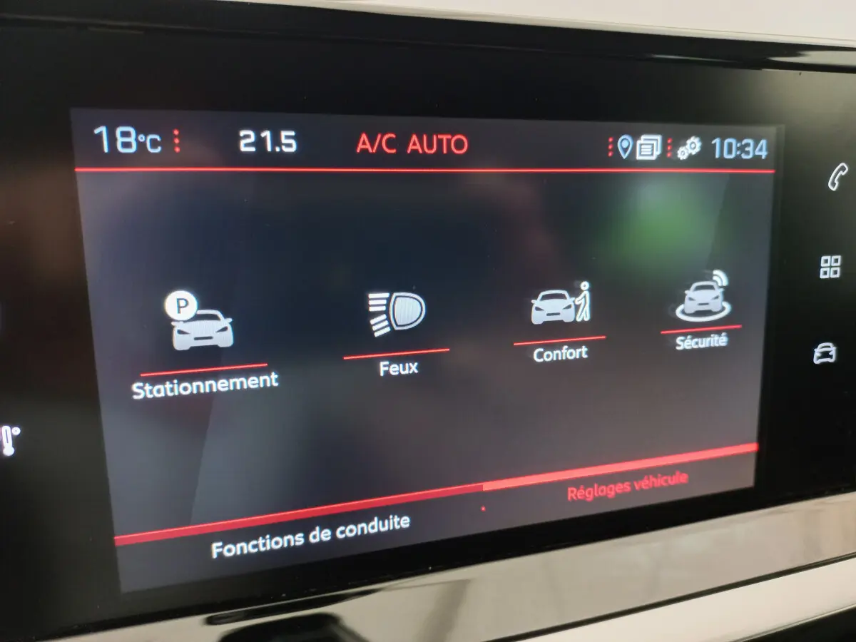 Écran tactile central de la Peugeot 208 PureTech 100 Allure affichant les réglages de conduite et climatisation à 10h34.