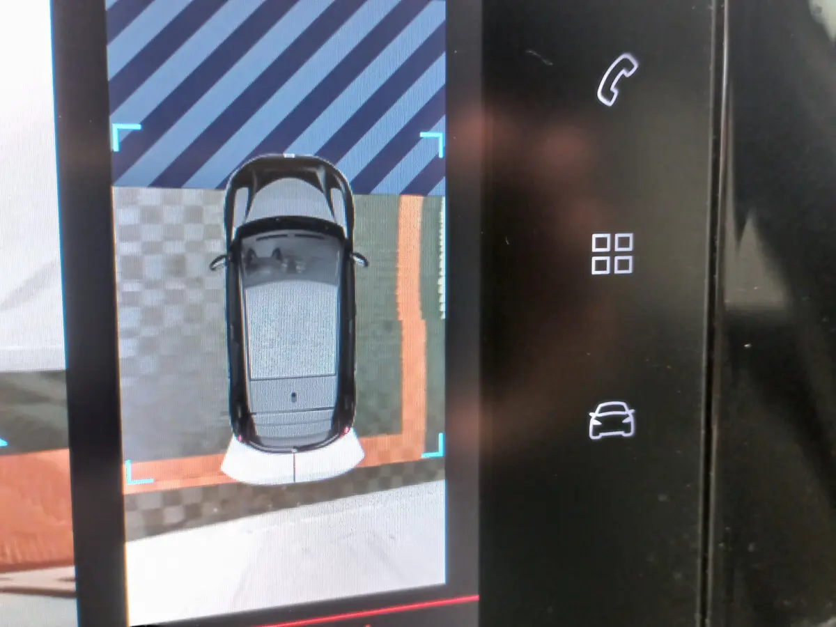 Affichage écran tactile montrant la vue aérienne d'une Peugeot 208 blanche en stationnement, avec capteurs de proximité visibles.