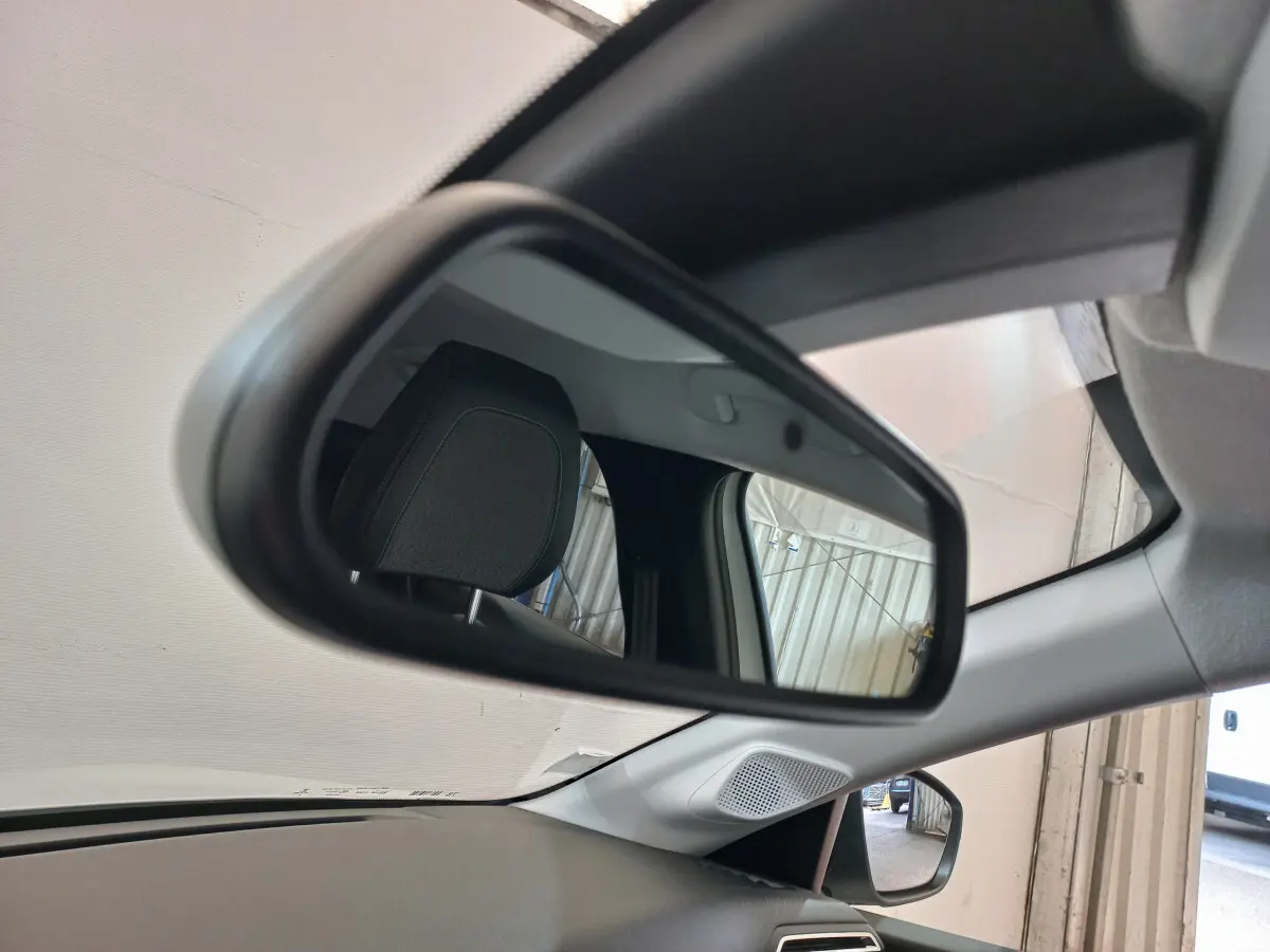 Rétroviseur intérieur de la Peugeot 208 PureTech 100 blanc, avec appui-tête et partie du tableau de bord visibles.