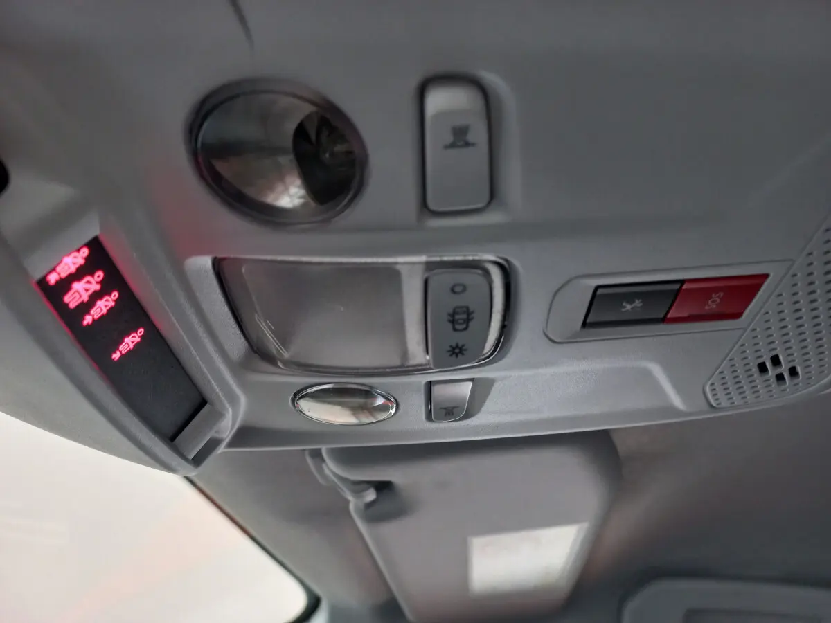 Vue intérieure du plafonnier avec commandes d'éclairage et bouton SOS dans une Peugeot 208 blanche PureTech 100 S&S Allure 2021.