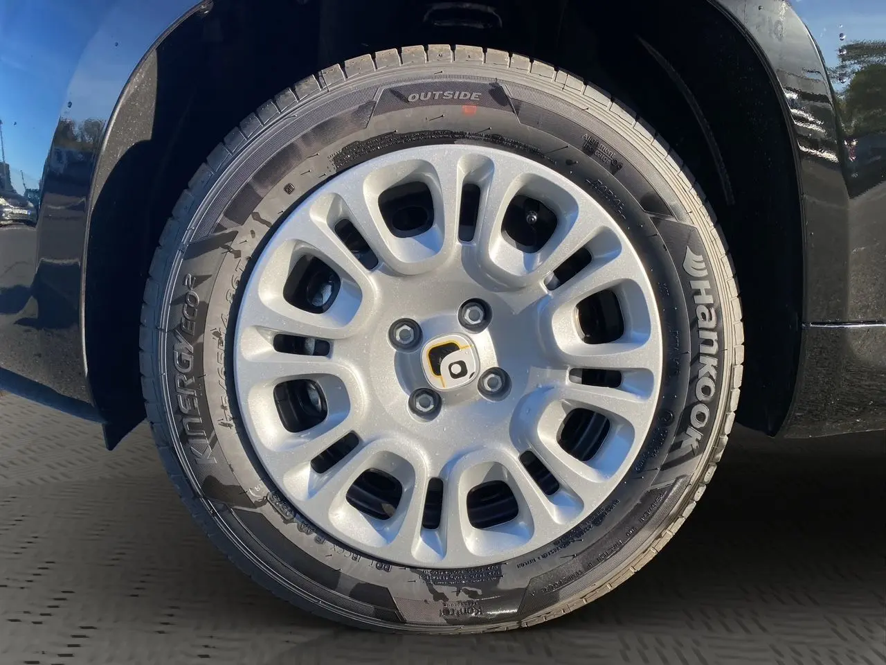 Gros plan sur la roue avant gauche noire de la Fiat Panda 2025 avec jante argentée et pneu Hankook.