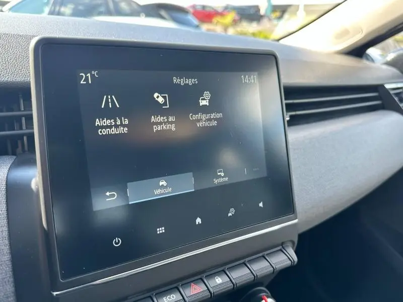 Écran tactile central de la Renault Clio gris Rafale 2025 montrant les réglages d'aides à la conduite et au parking.