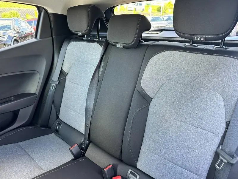 Vue intérieure sur la banquette arrière en textile gris 3D de la Renault Clio 2025 avec ceintures et appuie-têtes noirs.