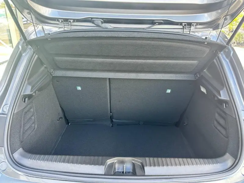 Coffre ouvert de la Renault Clio Gris Rafale 2025, montrant l'espace de chargement et la banquette arrière rabattable.