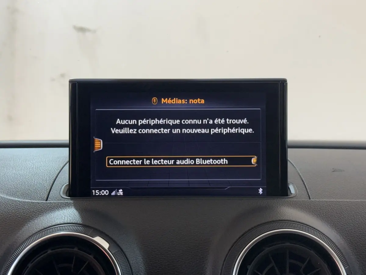 Écran central du système multimédia Audi A3 2018 affichant la connexion Bluetooth, entouré de deux aérateurs ronds noirs.