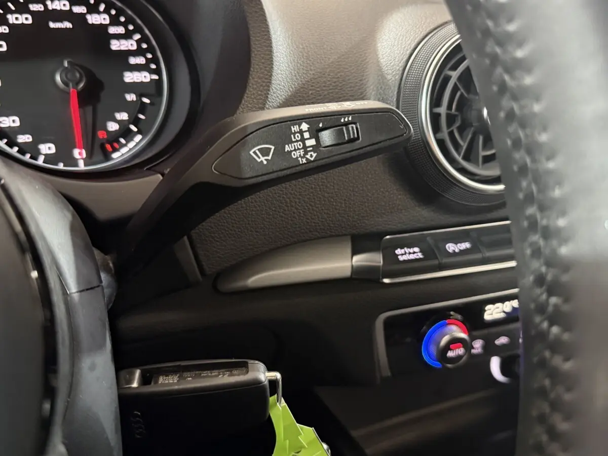 Gros plan intérieur sur le volant cuir et commandes du tableau de bord noir de l'Audi A3 2.0 TDI bleu 2018