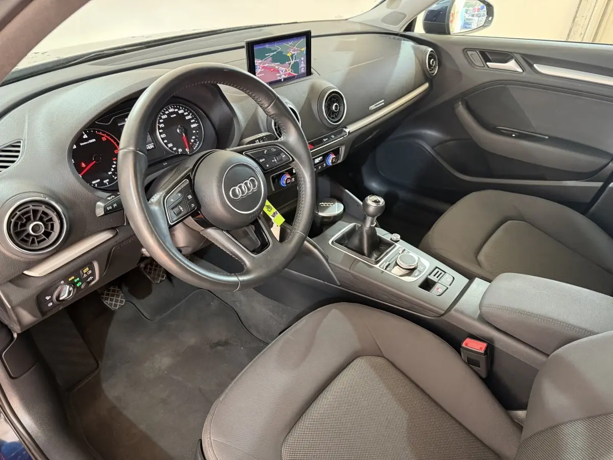Intérieur de l'Audi A3 2.0 TDI 150 Business Line 2018 vu côté conducteur, volant cuir et écran navigation visible.