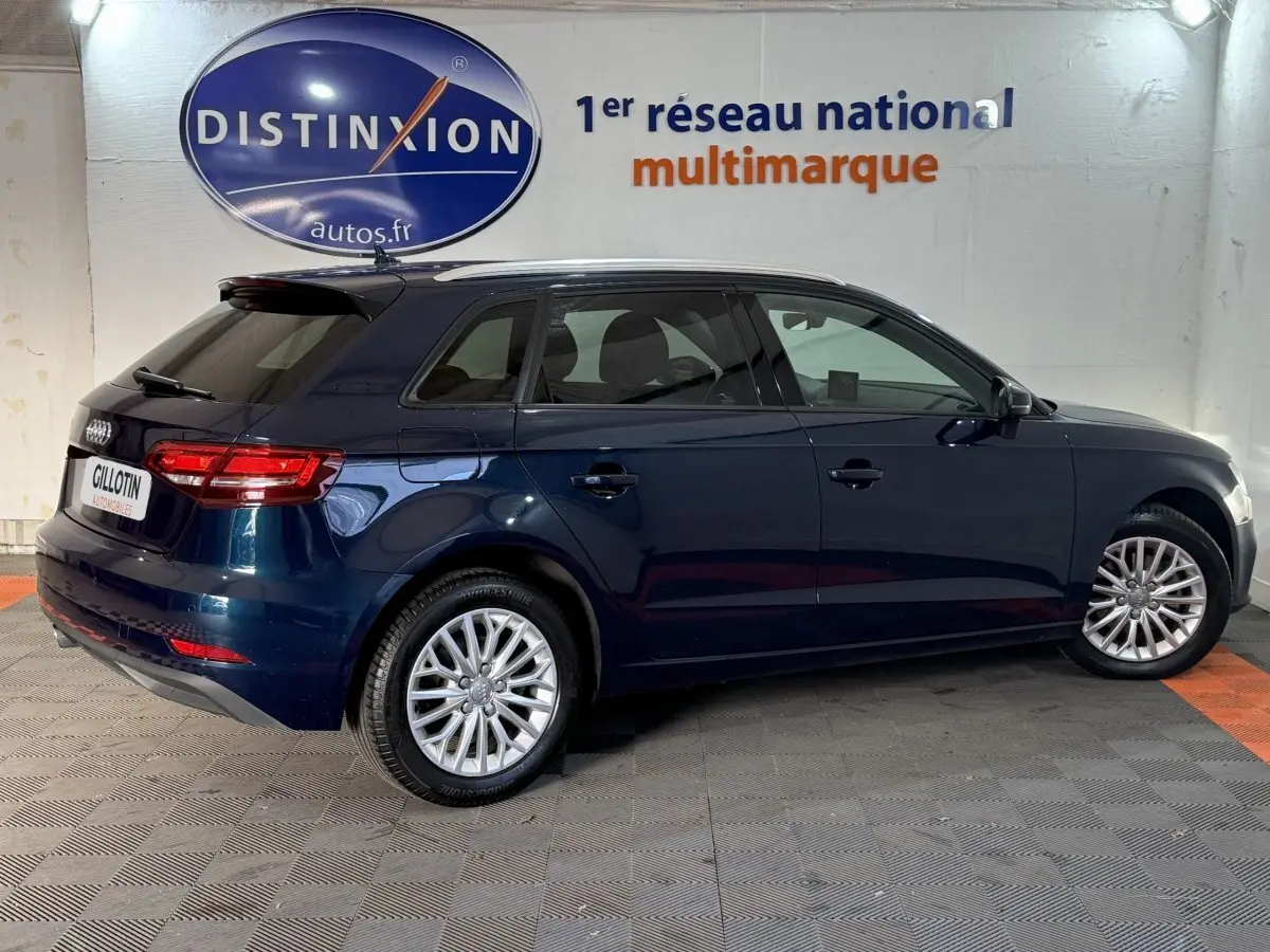 Audi A3 2.0 TDI bleu vue de profil côté droit dans un showroom avec jantes alliage et vitres teintées.
