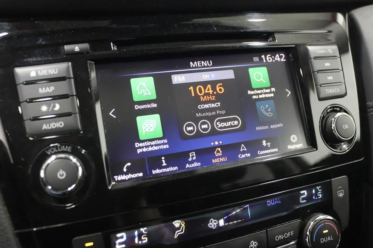 Gros plan sur l'écran tactile central et les commandes du tableau de bord du Nissan X-TRAIL gris métallisé.