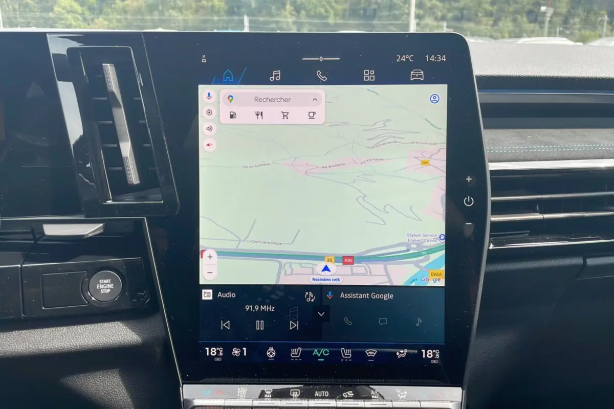 Vue rapprochée de l'écran tactile central du Renault Austral gris schiste, affichant la navigation GPS et les commandes climatisation.