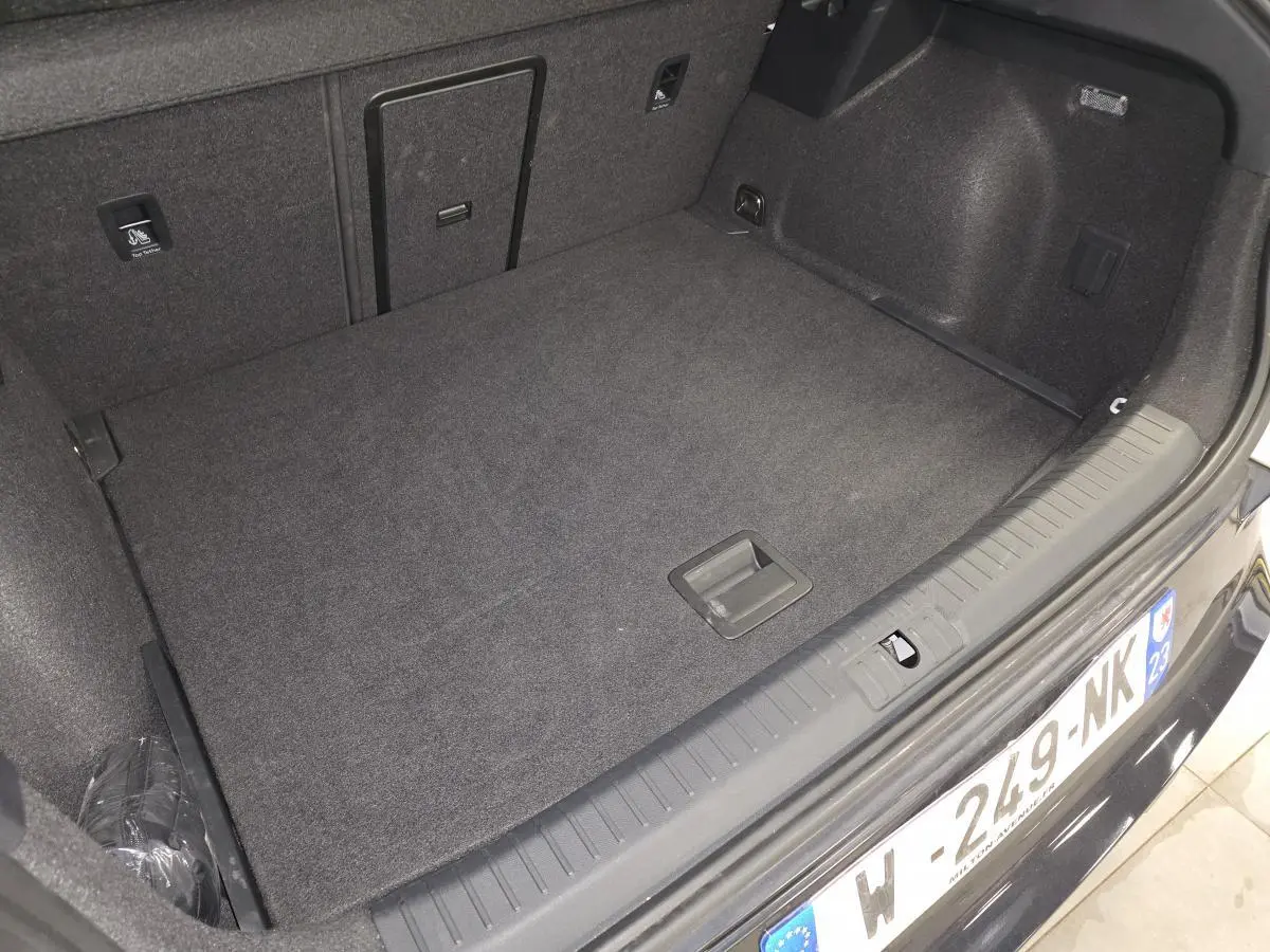 Coffre ouvert vu de l'arrière d'une CUPRA Formentor blanc, montrant un espace de chargement propre et tapissé.